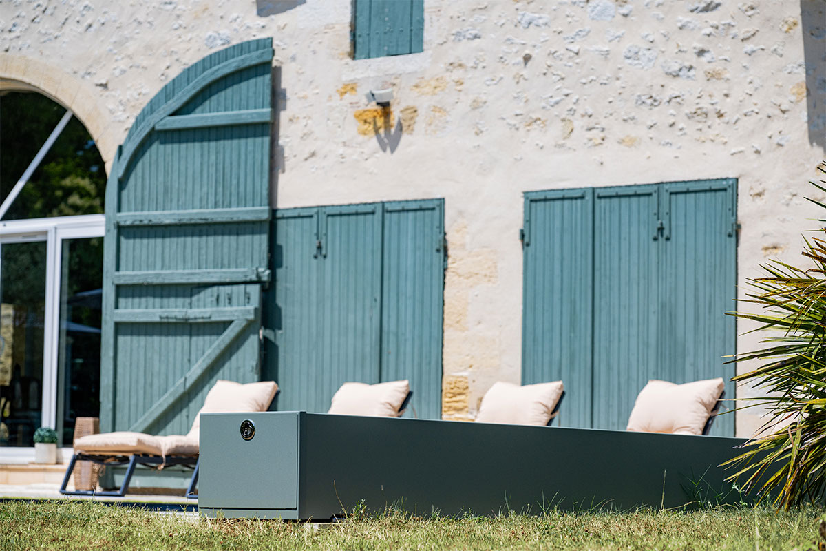 Gros plan sur le coffre de la Coverseal grise, design et discret, parfaitement intégré dans la terrasse.